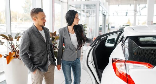 Concesionarios de coches de segunda mano - Hombre y mujer viendo coches usados en uno de los mejores concesionarios de coches de segunda mano en Barcelona