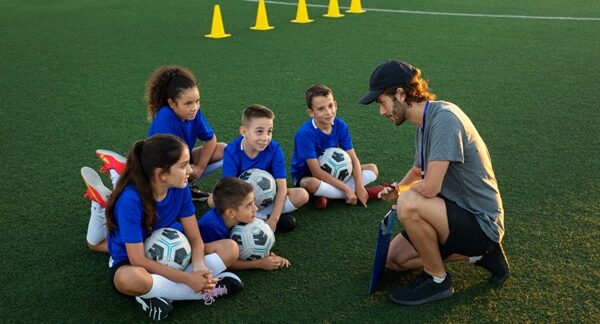 Escuelas de fútbol - Entrenador de academia de fútbol dando clases a jóvenes en una de las mejores escuelas de fútbol en Barcelona