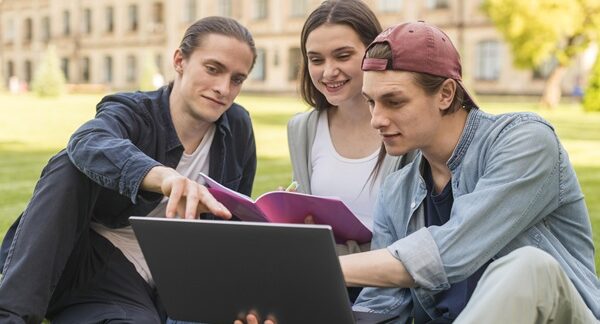 Universidades privadas - Jóvenes estudiantes de universidad sentados en el campus de una de las mejores universidades privadas en Barcelona