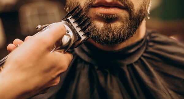 Barberías - Barbero de peluquería barbería cortando la barba de un hombre en una de las mejores barberías en Barcelona