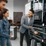 Tiendas de electrodomésticos - Vendedor de tienda de electrodomésticos ofreciendo aparatos eléctricos y utensilios del hogar a una pareja en una de las mejores tiendas de electrodomésticos en Barcelona