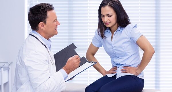 Proctólogos - Médico proctólogo reconocido como uno de los mejores proctólogos de Barcelona evaluando a una mujer en consulta de proctología por problemas en el colon
