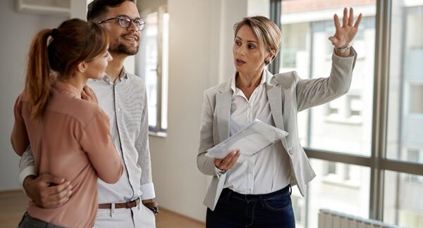 Agencias inmobiliarias - Asesora de inmobiliaria mostrando casas en venta a personas que buscan la compra o el alquiler de propiedades en Barcelona