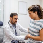 Especialistas del sistema digestivo - Mujer en consulta de gastroenterología siendo evaluada por un médico aparato digestivo reconocido como el mejor gastroenterólogo en Barcelona