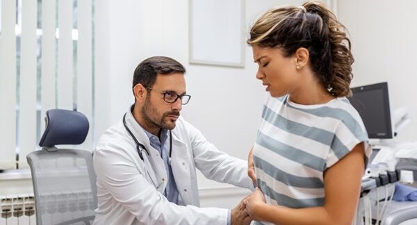 Especialistas del sistema digestivo - Mujer en consulta de gastroenterología siendo evaluada por un médico aparato digestivo reconocido como el mejor gastroenterólogo en Barcelona