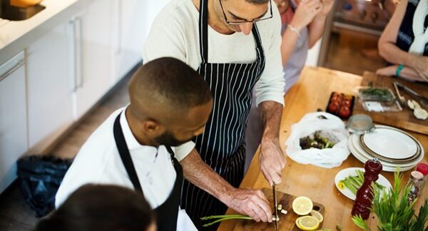 Escuelas de gastronomía - Cheff de academia de gastronomía enseñando a un cocinero en una de las mejores escuelas de gastronomía de Barcelona
