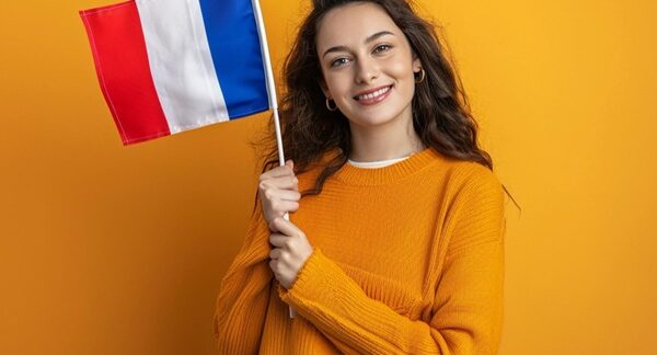Escuelas de francés - Estudiante de un curso de francés sosteniendo una bandera de Francia en las clases de francés de las mejores academias de francés en Barcelona