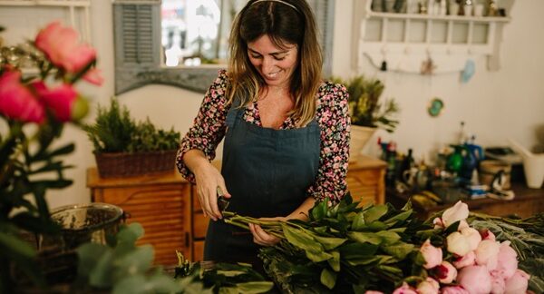 Floristerías - Mujer experta en arreglos florales armando un ramo de flores en una de las mejores floristerías de Barcelona