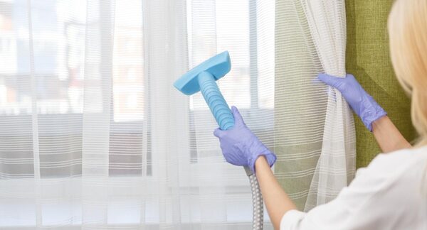 Servicios de lavado de cortinas - Personal de una de las mejores empresas de servicios de lavado de cortinas en Barcelona realizando el mantenimiento de cortinas a domicilio