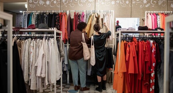 Tiendas de ropa vintage - Personas observando ropa de segunda mano para comprar ropa vintage en una de las mejores tiendas vintage de Barcelona