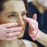 Clínicas de rinoplastia - Mujer que desea una operación de nariz siendo evaluada por un médico estético en una de las mejores clínicas de rinoplastia en Barcelona
