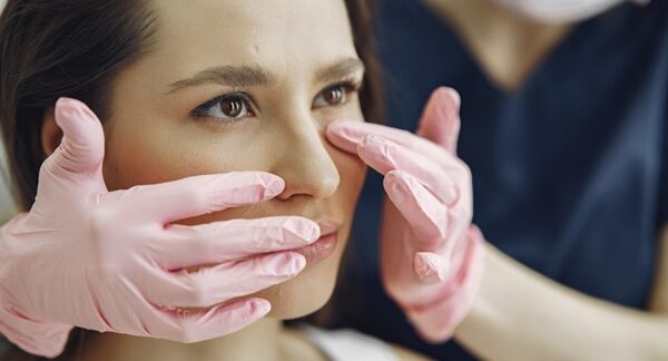 Clínicas de rinoplastia - Mujer que desea una operación de nariz siendo evaluada por un médico estético en una de las mejores clínicas de rinoplastia en Barcelona