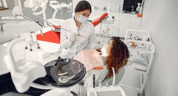 Hospitales de odontología - Dentista realizando un tratamiento dental a una mujer en la mejor clínica odontológica en Barcelona