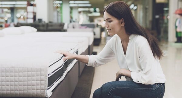 Tiendas de colchones - Mujer observando colchones baratos en las mejores tiendas de colchones de Barcelona