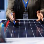 Instalación de sistemas fotovoltaicos - Trabajador mostrando una placa solar para obtener energía fotovoltaica en Barcelona