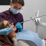 Periodoncistas - Dentista especialista en encías realizando un tratamiento periodontal a una mujer en la mejor clínica dental de Barcelona