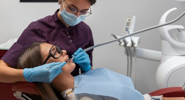 Periodoncistas - Dentista especialista en encías realizando un tratamiento periodontal a una mujer en la mejor clínica dental de Barcelona