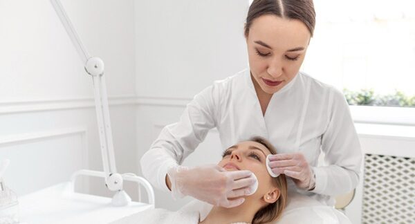 Dermatólogos estéticos - Dermatólogo realizando un tratamiento facial a una mujer en la mejor clínica dermatológica en Barcelona